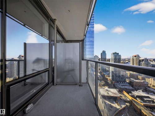 The property features a balcony with glass railings, offering expansive views of the city skyline and surrounding buildings - 2612 10360 102 Street, Edmonton, AB - Outdoor With Balcony With View With Exterior