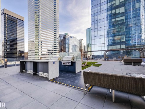 Exclusive Residents Area. Patio with views of city buildings, featuring outdoor kitchen facilities with grills and sinks, a paved surface, and artificial turf areas - 2612 10360 102 Street, Edmonton, AB - Outdoor With Facade