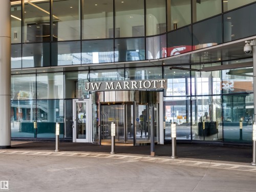 The property features a modern glass facade with a revolving door entrance - 2612 10360 102 Street, Edmonton, AB - 
