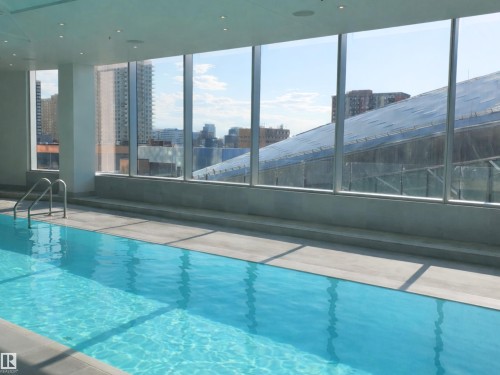 The property features a swimming pool with a metal handrail, large windows, and recessed lighting in the ceiling - 2612 10360 102 Street, Edmonton, AB -  Photo Showing Other Room With In Ground Pool