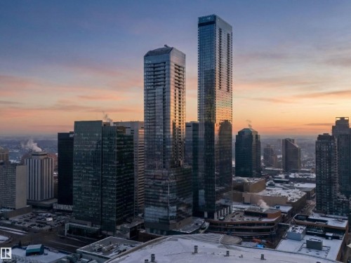 This aerial view showcases a vibrant city environment with numerous high-rise buildings and a striking sunset horizon - 2612 10360 102 Street, Edmonton, AB - Outdoor With View