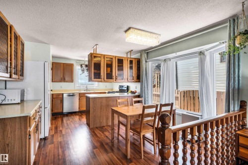 The kitchen features wood cabinetry, a stainless steel dishwasher, and a bay window providing natural light - 18923 86A Avenue, Edmonton, AB - Indoor Photo Showing Other Room