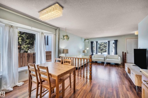The property features wood flooring, large windows, and a decorative ceiling light fixture - 18923 86A Avenue, Edmonton, AB - Indoor Photo Showing Dining Room