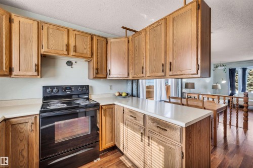 The kitchen features light wood cabinetry, light countertops, and a black electric range - 18923 86A Avenue, Edmonton, AB - Indoor Photo Showing Kitchen