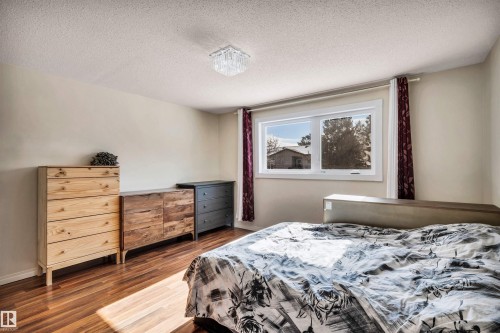 The room features hardwood flooring, a bright window, and a ceiling-mounted light fixture - 18923 86A Avenue, Edmonton, AB - Indoor Photo Showing Bedroom