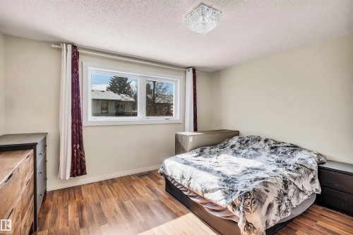 This room features a window providing natural light, hardwood style flooring, and a contemporary ceiling light fixture - 18923 86A Avenue, Edmonton, AB - Indoor Photo Showing Bedroom