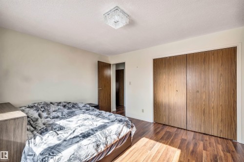 This room features light-colored walls, wood-look flooring, and a modern ceiling light fixture - 18923 86A Avenue, Edmonton, AB - Indoor Photo Showing Bedroom