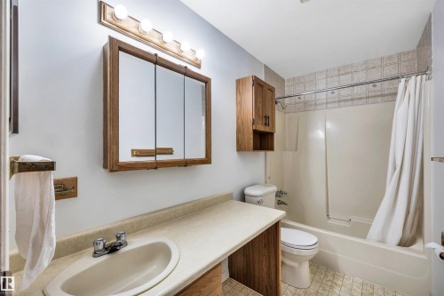 Bathroom featuring a vanity with an integrated sink, a medicine cabinet with a wood frame, and a shower/tub combination - 18923 86A Avenue, Edmonton, AB - Indoor Photo Showing Bathroom
