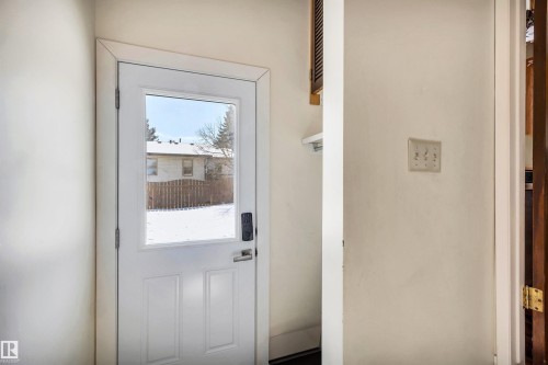 Entry door with a window pane and a dark-toned handle, providing a view of the outdoor area - 18923 86A Avenue, Edmonton, AB - Indoor Photo Showing Other Room