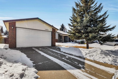 The property features a brick exterior with white siding accents and an attached garage with a white garage door - 18923 86A Avenue, Edmonton, AB - Outdoor