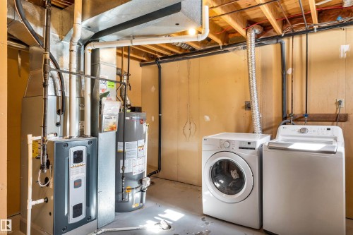 Utility area featuring a water heater, furnace, and washer and dryer - 18923 86A Avenue, Edmonton, AB - Indoor Photo Showing Laundry Room