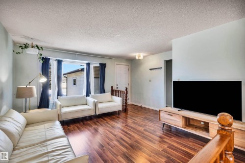 Spacious living area featuring rich wood flooring, ample natural light from a large window, and a light-toned ceiling - 18923 86A Avenue, Edmonton, AB - Indoor Photo Showing Living Room