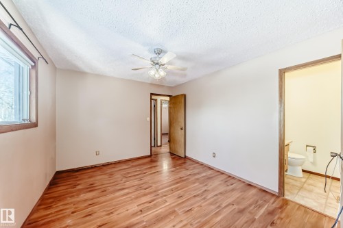 Interior room featuring wood-style flooring, a window with wood trim, and a ceiling fan - 100 23016 Twp Rd 504, Rural Leduc County, AB - Indoor Photo Showing Other Room