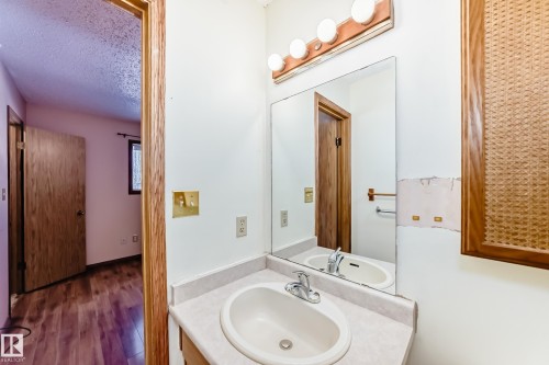The bathroom features a vanity with an integrated sink and a large mirror - 100 23016 Twp Rd 504, Rural Leduc County, AB - Indoor Photo Showing Bathroom