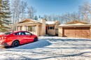 The property features a detached garage with a brown door, a beige exterior, and a snow-covered driveway - 100 23016 Twp Rd 504, Rural Leduc County, AB  - Outdoor 