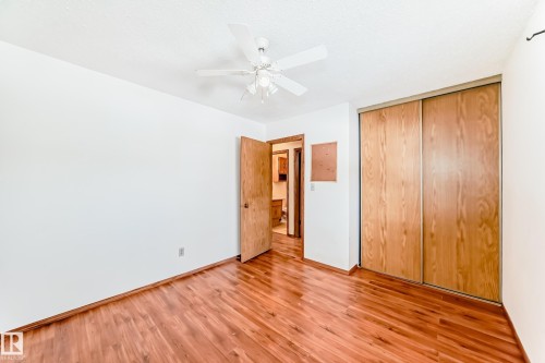 The room features hardwood floors, a white ceiling fan, and a closet with sliding wooden doors - 100 23016 Twp Rd 504, Rural Leduc County, AB - Indoor Photo Showing Other Room