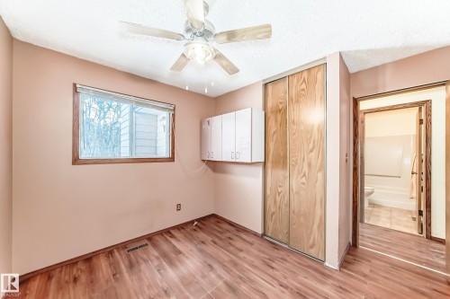 This room features wood-look flooring, a window with wood trim, and a ceiling fan - 100 23016 Twp Rd 504, Rural Leduc County, AB - Indoor Photo Showing Other Room