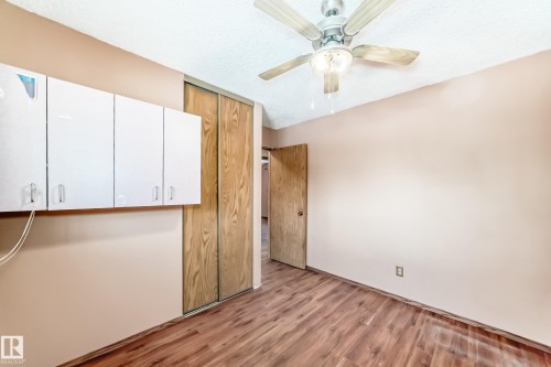 Interior room featuring wood-style flooring, a ceiling fan with integrated lighting, and a closet with sliding wooden doors - 100 23016 Twp Rd 504, Rural Leduc County, AB - Indoor Photo Showing Other Room