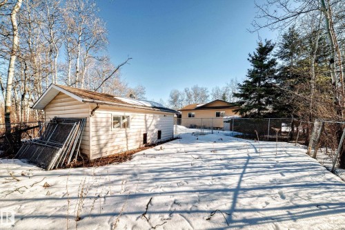 The property includes a detached outbuilding with light-colored siding, a brown roof, and a visible window - 100 23016 Twp Rd 504, Rural Leduc County, AB - Outdoor