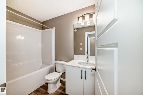 Bathroom featuring a white vanity with a white countertop, undermount sink, and chrome faucet - 20415 16 Avenue, Edmonton, AB 
