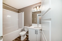 Bathroom featuring a white vanity with a white countertop, undermount sink, and chrome faucet - 