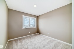 Room featuring neutral-toned walls, white trim, and a window with divided lites - 