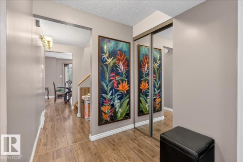 The entryway features wood-style flooring and a mirrored closet, enhancing the sense of space - 3240 130A Avenue, Edmonton, AB - Indoor Photo Showing Other Room