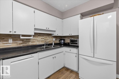 Kitchen featuring white cabinetry, a dual basin sink, a white dishwasher, and a white refrigerator - 3240 130A Avenue, Edmonton, AB - Indoor Photo Showing Kitchen With Double Sink