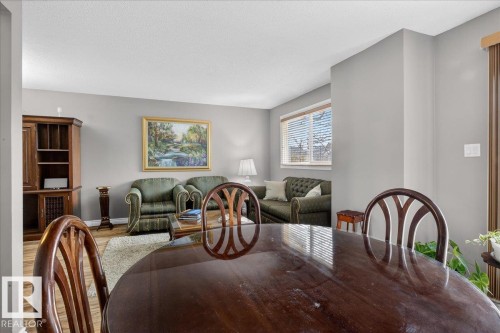 This interior space features light gray walls, wood-look flooring, and a window with blinds - 3240 130A Avenue, Edmonton, AB - Indoor Photo Showing Dining Room