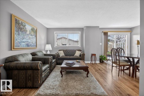 Living area with hardwood flooring, light grey walls, and a window with white blinds - 3240 130A Avenue, Edmonton, AB - Indoor Photo Showing Living Room