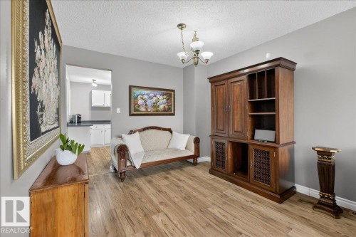 This room features hardwood-style flooring and light grey walls - 3240 130A Avenue, Edmonton, AB - Indoor Photo Showing Other Room