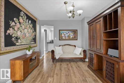 The property features hardwood floors, a brass chandelier, and a neutral color palette - 3240 130A Avenue, Edmonton, AB - Indoor