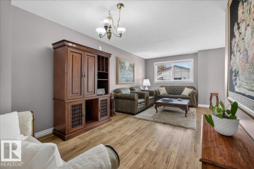 The living area features durable flooring, light-colored walls, and a window providing natural light - 3240 130A Avenue, Edmonton, AB - Indoor Photo Showing Living Room