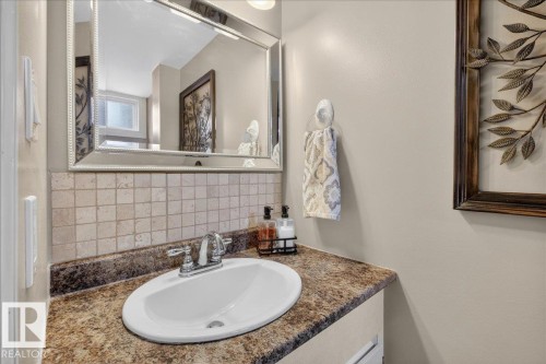 Bathroom vanity with an oval sink, chrome faucet, and tiled backsplash - 3240 130A Avenue, Edmonton, AB - Indoor Photo Showing Bathroom