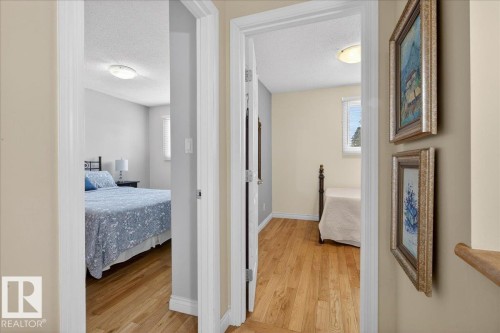 The property features hardwood flooring in the hallway and rooms, neutral wall colors, and ceiling light fixtures - 3240 130A Avenue, Edmonton, AB - Indoor Photo Showing Other Room
