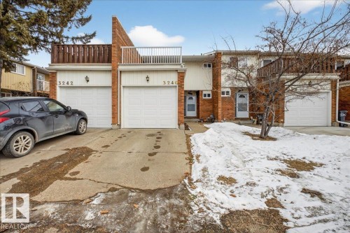 The property features a brick exterior, an attached garage with a white door, and a private balcony with a white railing - 3240 130A Avenue, Edmonton, AB - Outdoor With Balcony