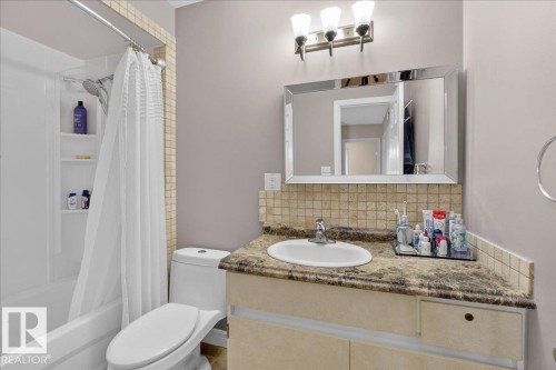 Bathroom with a tub and shower combination, a vanity with a counter and an integrated sink, and a mirrored cabinet - 3240 130A Avenue, Edmonton, AB - Indoor Photo Showing Bathroom