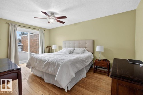 This room features hardwood floors, a ceiling fan, and sliding glass doors that provide direct access to an outdoor space - 3240 130A Avenue, Edmonton, AB - Indoor Photo Showing Bedroom