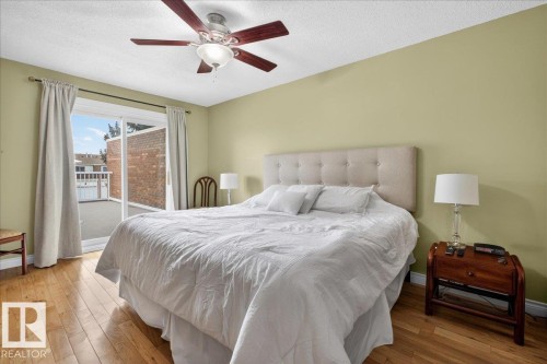 This room features hardwood flooring, a ceiling fan with light, and a light-colored headboard with tufted detailing - 3240 130A Avenue, Edmonton, AB - Indoor Photo Showing Bedroom