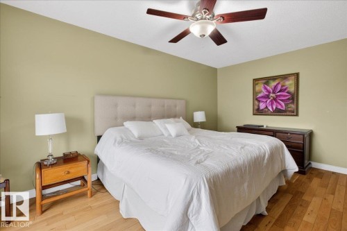 Bedroom featuring hardwood floors, a neutral-toned headboard, and a ceiling fan - 3240 130A Avenue, Edmonton, AB - Indoor Photo Showing Bedroom