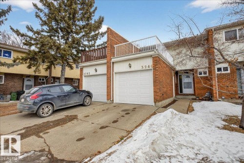 The property features a brick exterior with white garage doors and a white front entrance door - 3240 130A Avenue, Edmonton, AB - Outdoor