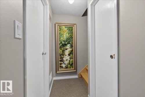 Hallway with light gray walls, white doors, and a neutral-toned carpet - 3240 130A Avenue, Edmonton, AB - Indoor Photo Showing Other Room