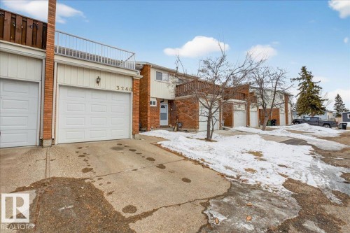 The property features a brick exterior with white siding, a single-car garage, and a balcony with a white railing - 3240 130A Avenue, Edmonton, AB - Outdoor