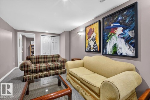 The living area features a neutral paint palette, carpeted flooring, and wall-mounted lighting - 3240 130A Avenue, Edmonton, AB - Indoor