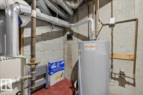 The property includes a water heater and a furnace, with exposed ductwork and piping - 3240 130A Avenue, Edmonton, AB - Indoor Photo Showing Basement