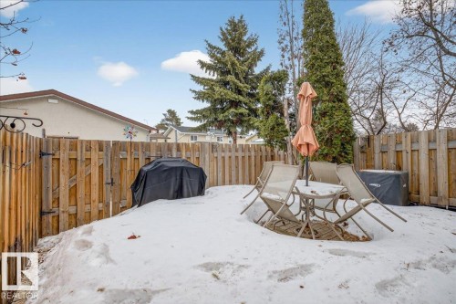 The property features a fenced yard with mature trees and an outdoor seating area - 3240 130A Avenue, Edmonton, AB - Outdoor With Deck Patio Veranda