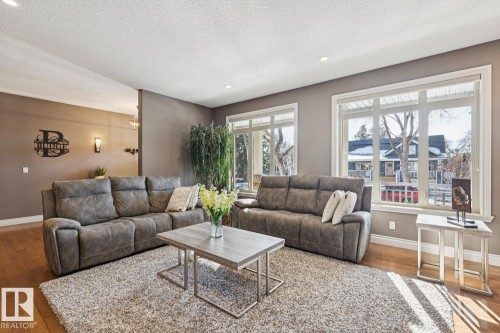 The living area features hardwood flooring, a neutral color palette on the walls, and recessed lighting - 11409 63 Street Nw, Edmonton, AB - Indoor Photo Showing Living Room