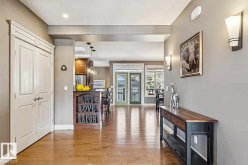 The property features hardwood floors and a bright, inviting entryway with recessed lighting and wall sconces - 11409 63 Street Nw, Edmonton, AB - Indoor