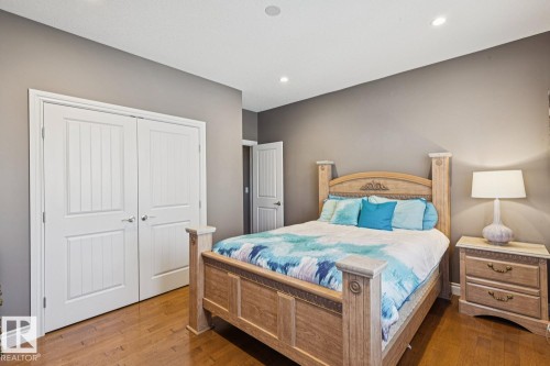 This room features hardwood flooring, white paneled double doors, and recessed ceiling lighting - 11409 63 Street Nw, Edmonton, AB - Indoor Photo Showing Bedroom