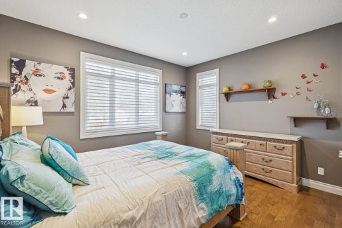 This room features hardwood flooring, recessed lighting, and two windows with blinds - 11409 63 Street Nw, Edmonton, AB - Indoor Photo Showing Bedroom